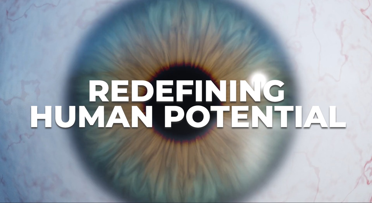 Close-up of a human eye in sharp detail with the words “REDEFINING HUMAN POTENTIAL” in bold white text centered across the image.